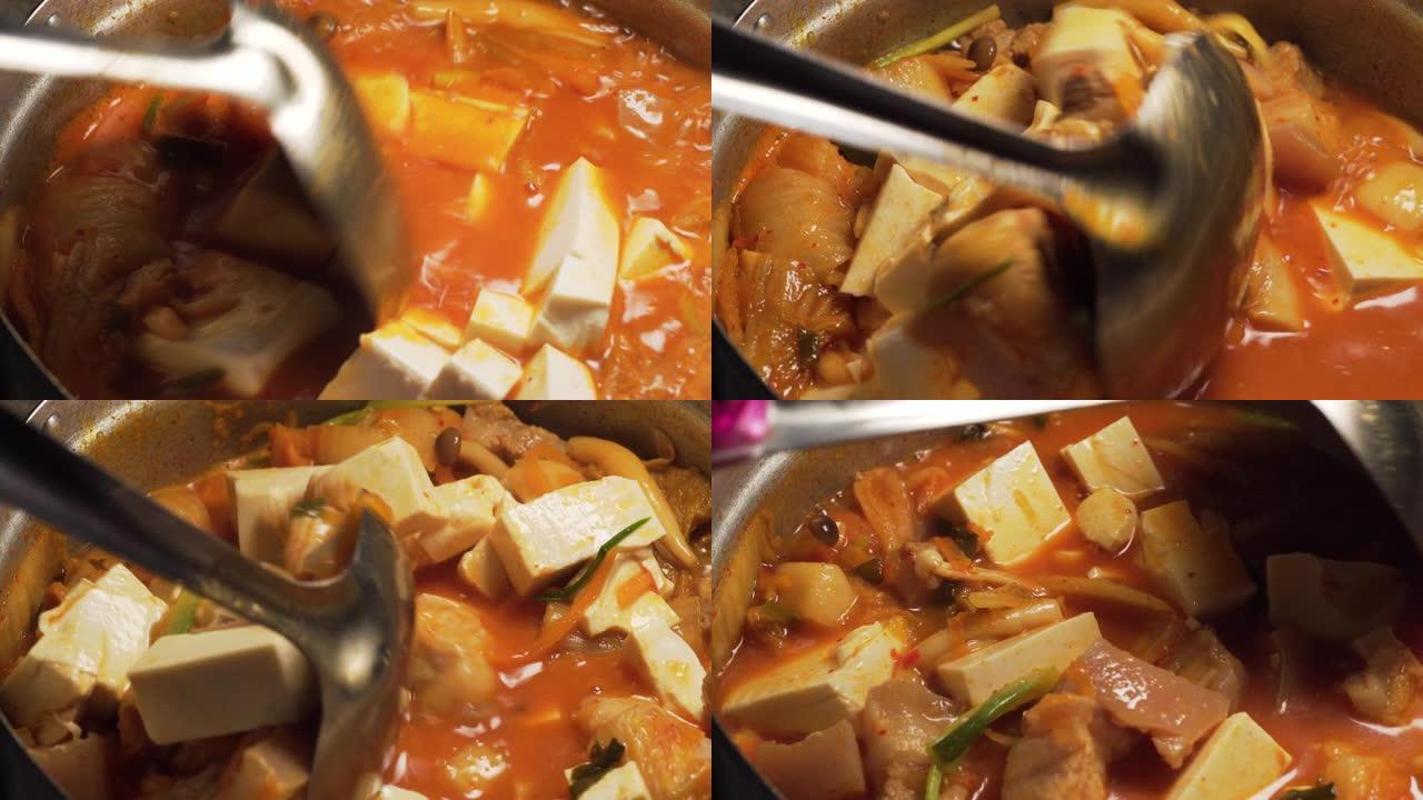 有人在锅里搅拌泡菜汤的食谱。又热又辣。韩国传统食品。