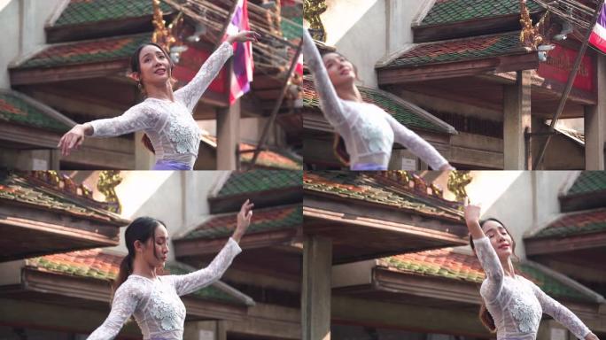 以下是前头镜头: 亚洲美丽的芭蕾舞演员在当地的城市景观街道上练习积极的情感，微笑着，泰国当地地标曼谷