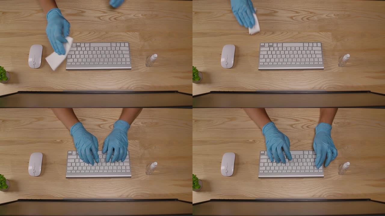 检疫时，一名男子在餐巾纸上喷洒消毒剂，并在办公室或家中擦拭电脑键盘。工作场所卫生，防止病毒感染。双手