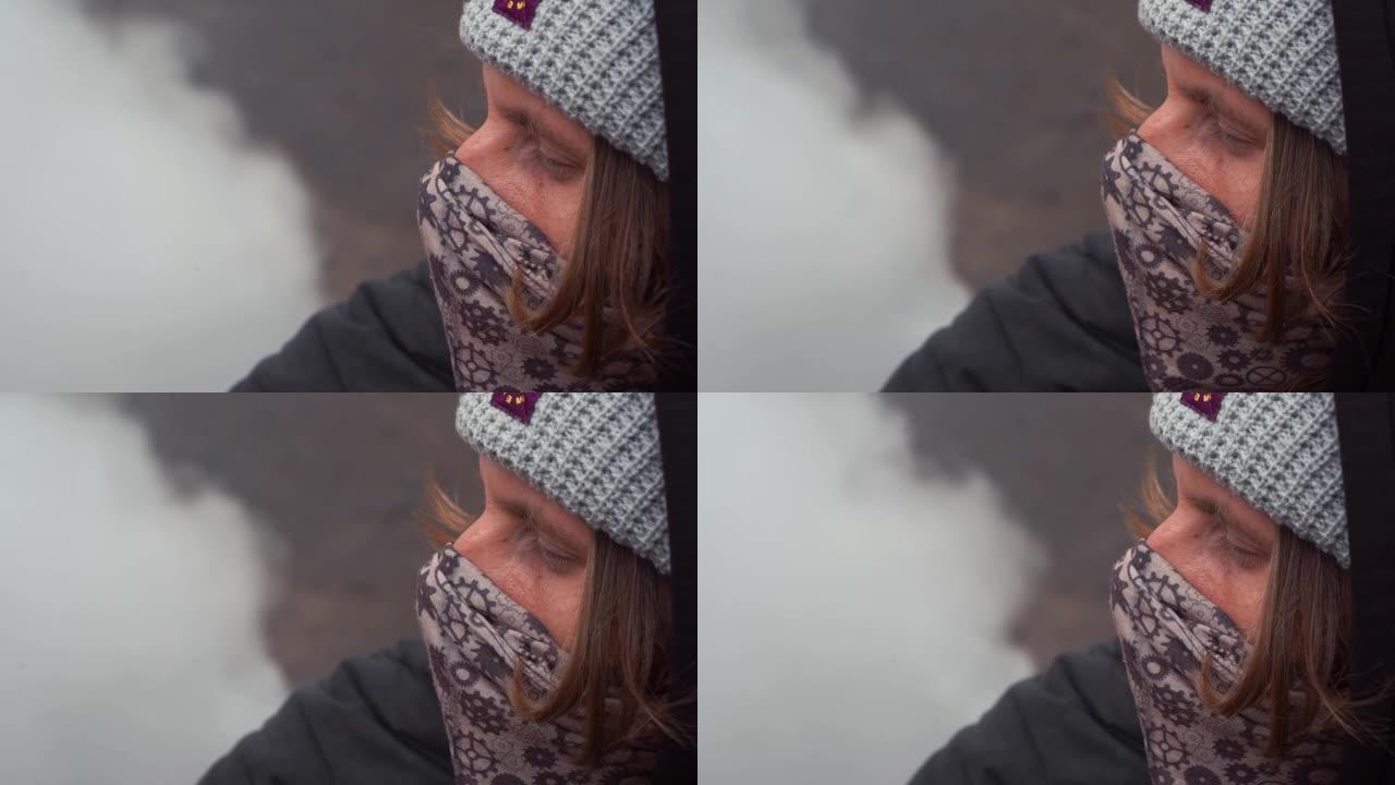 戴着面具的年轻人看着堪察加半岛活火山上冒烟的喷气孔