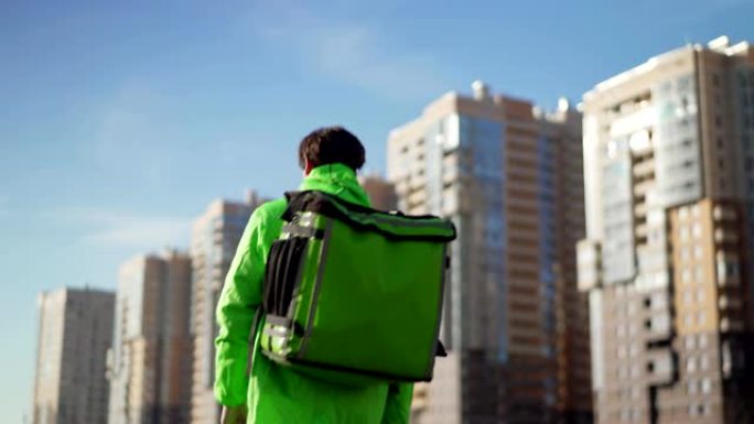 Rear view of delivery man in green uniform with th