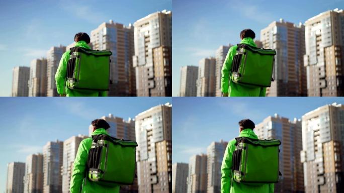 Rear view of delivery man in green uniform with th