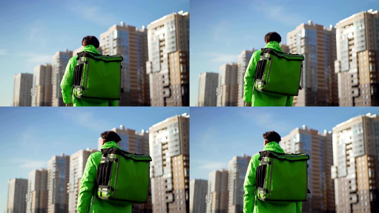 Rear view of delivery man in green uniform with th