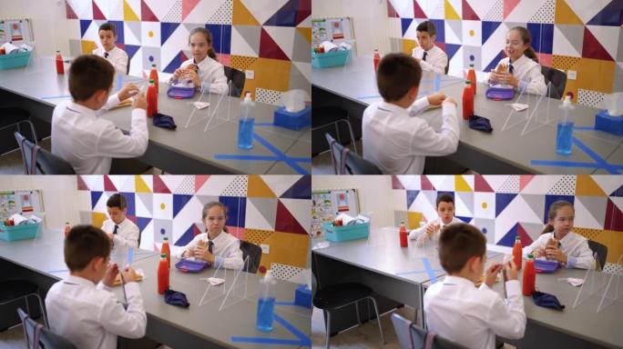 小学生在 “新常态” 学校环境中吃午餐