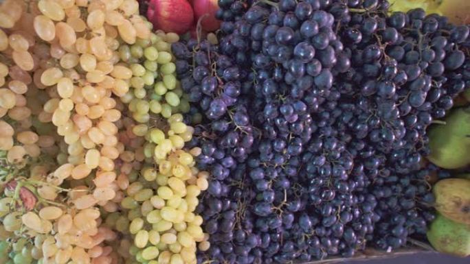 当地农场食品市场上不同的新鲜水果、白葡萄和红葡萄和梨