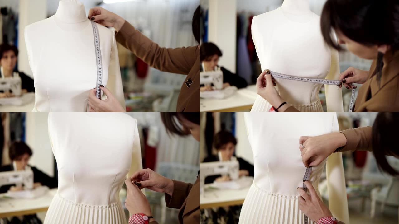 一位专业的女裁缝在制作新的时尚布料时，用卷尺在人体模型上采取措施。裁缝工作室。概念: 时尚，裁缝，购