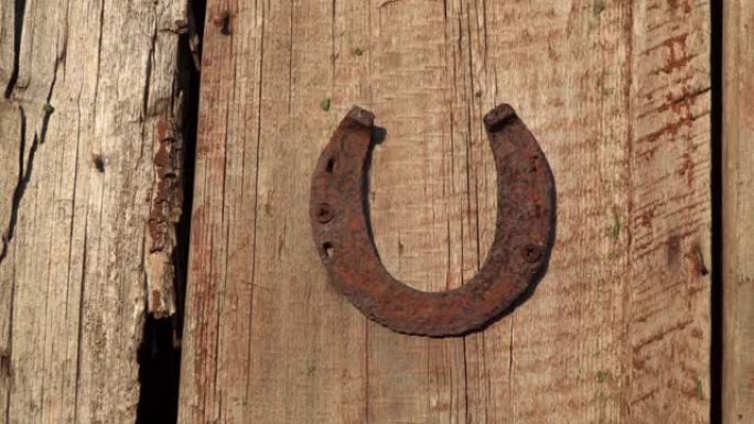 一块生锈的马蹄铁钉在木板上。
