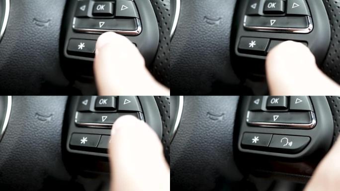 开车时手指按下方向盘上的智能系统按钮语音控制 (i-smart) 的特写。