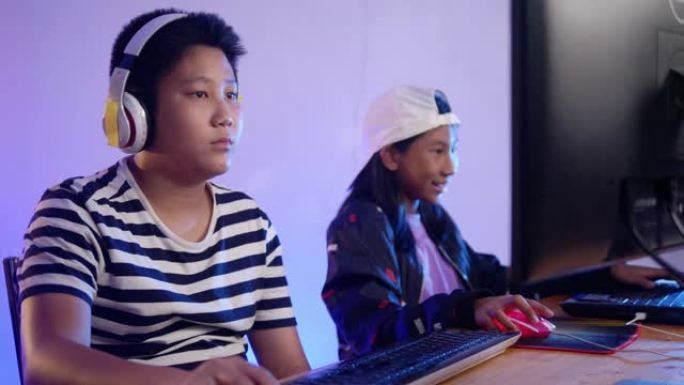 快乐的亚洲孩子晚上在家玩网络游戏和发光二极管灯，生活方式理念。