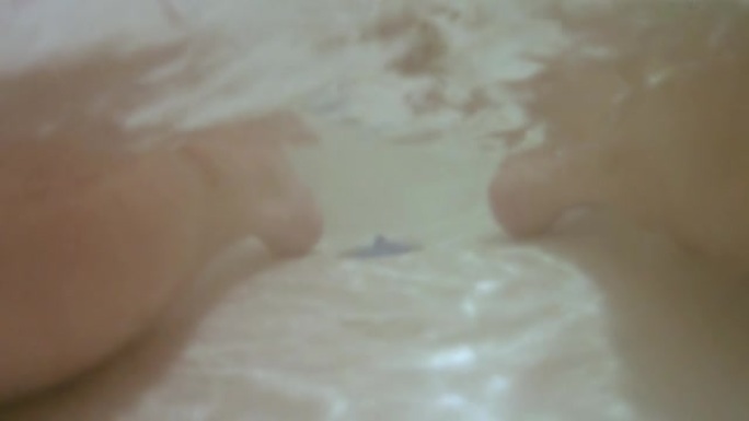 浴室里的人。水下摄像机。悬挂双腿。