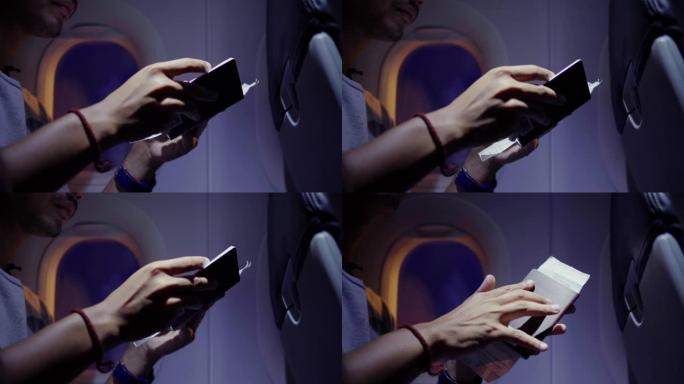 CU向上倾斜手面对等待的飞机飞行场景。亚洲男子在飞机上使用智能手机