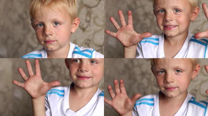 一个脸脏手脏的小男孩在家里的特写肖像。