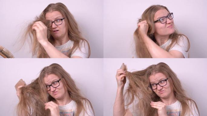 戴眼镜的可爱金发女孩试图用木刷梳理稀薄纠结的长发，在白色背景上做一个时尚的发型，但没有成功。护理问题