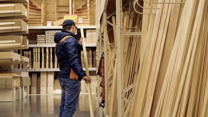 年轻人在建材商店选择木梁。