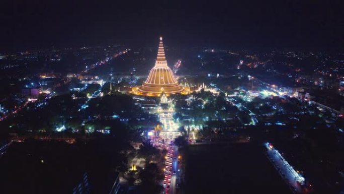 晚上Phra Pathommachedi寺的空中俯视图。带有民居的金色佛教宝塔，泰国纳康帕通区城市。