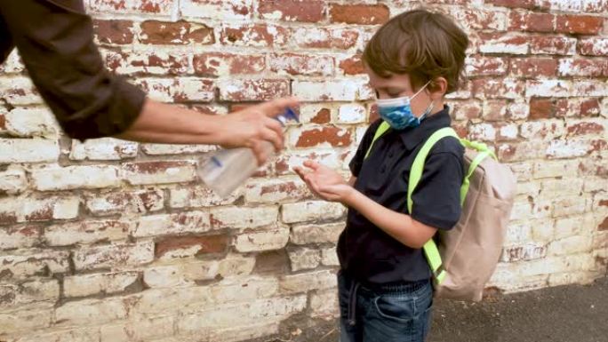 女教师在城市环境中对学龄前学生的手使用消毒剂凝胶