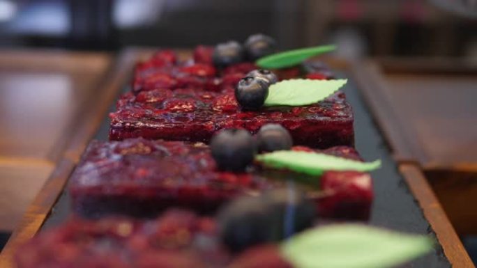 用蓝莓装饰的红色天鹅绒浆果果冻蛋糕系列，留在糕点店