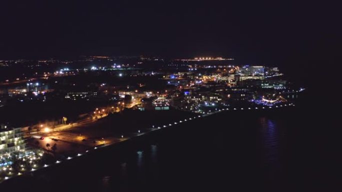 帕福斯堤防或长廊在夜间的鸟瞰图，并在海水中反射城市灯。著名的塞浦路斯地中海度假胜地