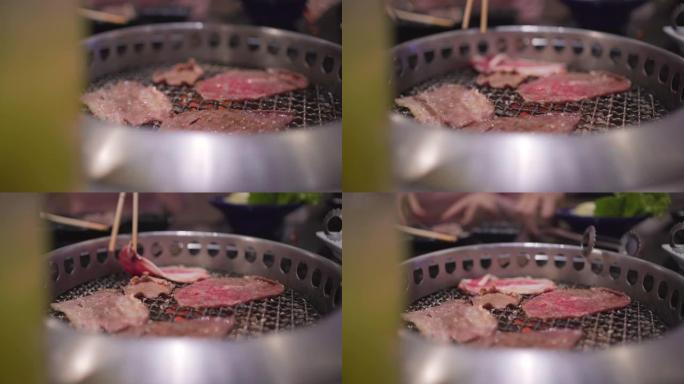 4k银通，筷子拿起新鲜的红色牛肉片放入烧烤架，日式餐厅，煤火，日式餐厅，午餐时间，火焰烤，主菜，肉类