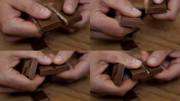 男人打破巧克力棒。慢动作。特写。手打碎了一块巧克力。特写。