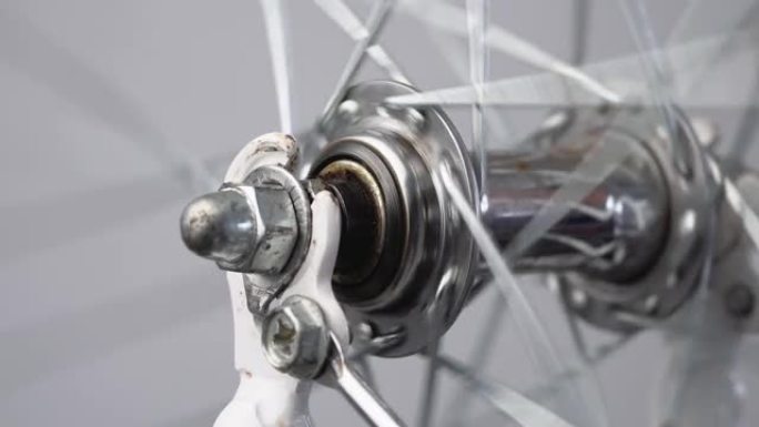 自行车前轮的特写旋转，前轮毂在前叉上带有辐条。