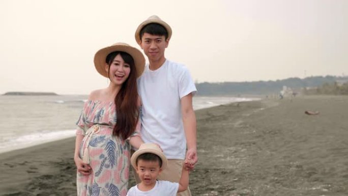 快乐的亚洲家庭在海滩上玩得开心