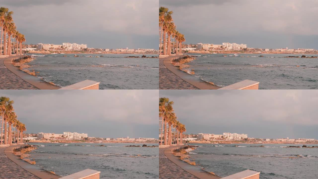 帕福斯码头。塞浦路斯的旅游长廊。粉红色黄昏的旅游区。迷人的男跑步者在岩石海滩训练。地中海沿岸。风雨如