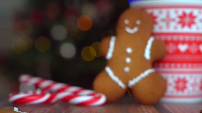 圣诞视频姜饼人红色马克杯，圣诞装饰品上有圣诞圣诞树和红色条纹节日糖果。圣诞糖果和木底棉花糖杯子。4k