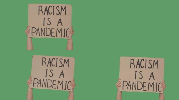 双手举着标语 “种族主义是一场流行病” 的海报，背景是绿屏，色键。停止种族主义概念，不要种族主义。特