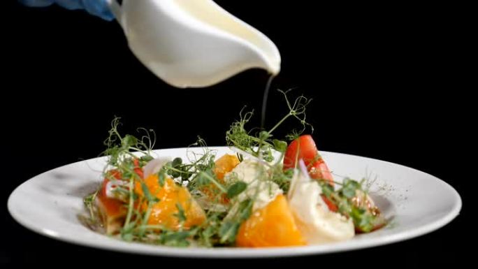健康食品和素食概念。在沙拉上倒橄榄油。从白瓷碗中倒出的特级初榨橄榄油的慢动作镜头。高清