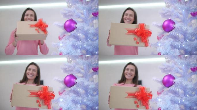 模糊的时间流逝，妈妈多么快乐，在圣诞树下为自己找到了礼物，并将其扩展到相机上，感到感激。