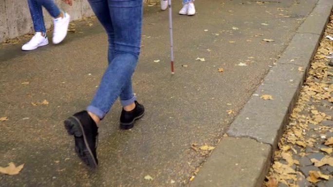 用棍子在人行道上行走的盲人特写。残障，自治，独立