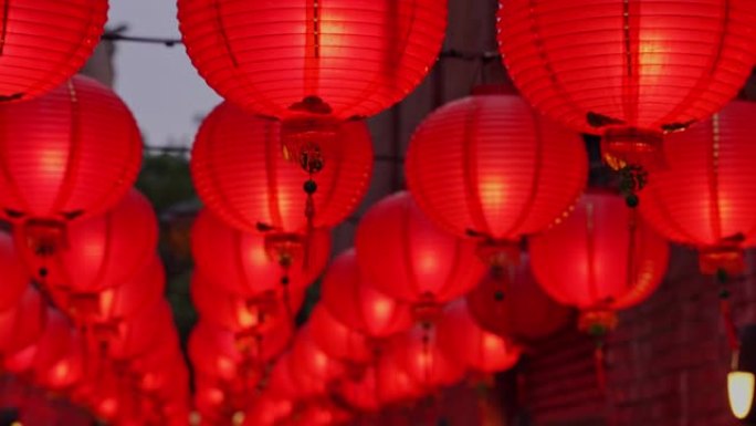 晚上走在中国传统街道上，美丽的圆形红灯笼悬挂着摇曳，是农历新年的概念。