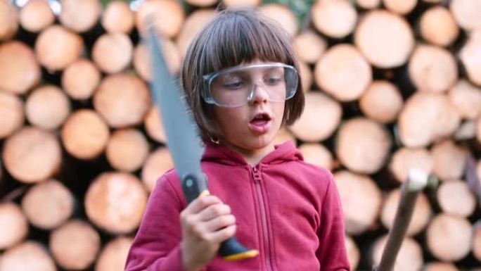 一个戴着锯子和棍子的戴眼镜的男孩的肖像。制作木制工艺品。