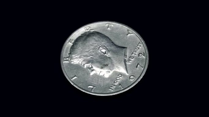 美国硬币半美元1972释放在黑色背景上旋转。宏观。特写