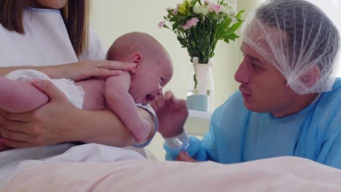 爸爸和妈妈在医院病房里抚慰哭泣的新生婴儿