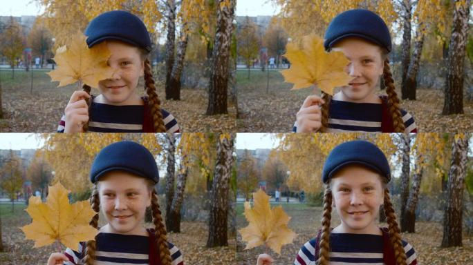 快乐的女孩在公园里抱着树叶，眯着眼睛