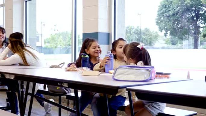可爱的小学生在学校食堂享用午餐
