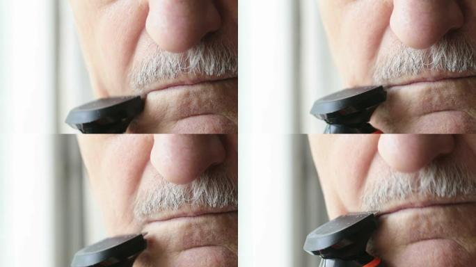 一个老人的胡子用修剪器修剪。