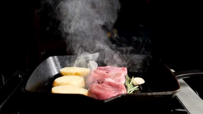 超级慢动作食物烹饪镜头。用烤架煮土豆和肉。餐厅的厨师用白烟烹饪美味的烤肉。高清