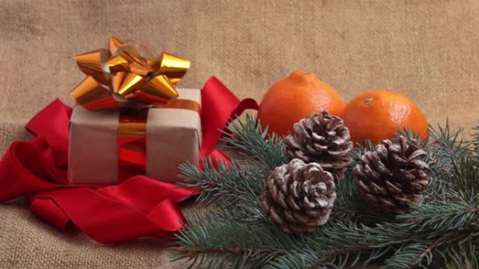 新年礼物落在框架中的桌子上。新年的组成，橘子，松果和新年树的树枝被解雇。