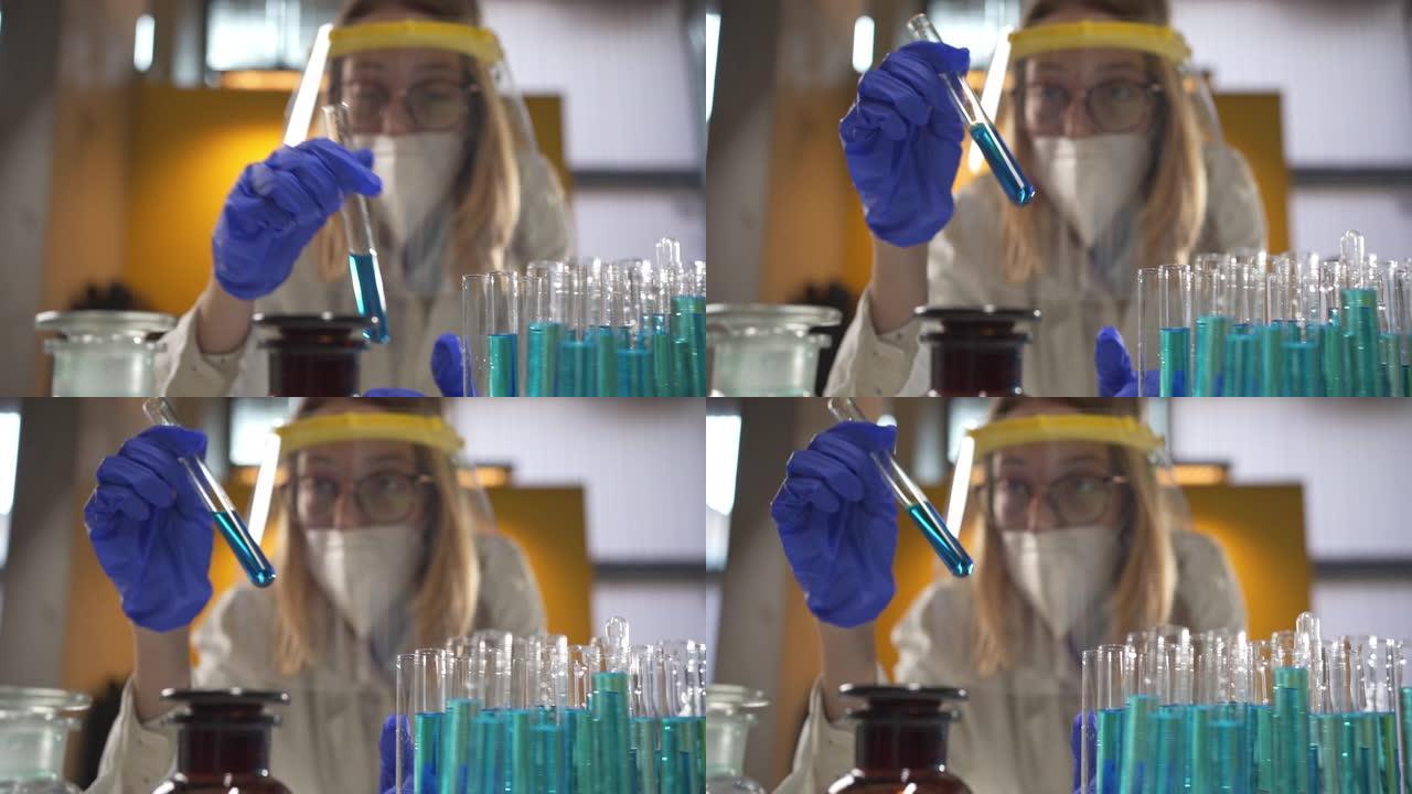 女性生物化学家在分析反应时将蓝色化学物质混合到玻璃试管中
