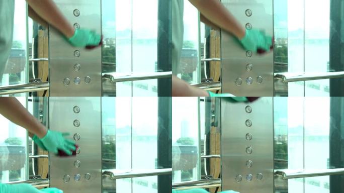 男士员工使用湿巾清洁带蓝色消毒瓶的电梯按钮控制面板。消毒、清洁和保健、抗电晕病毒、新型冠状病毒肺炎