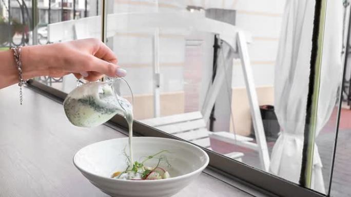 无缝的电影胶片或无尽的移动与复制空间。手将蔬菜汤倒入白盘