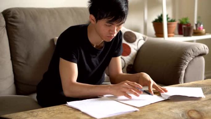 亚洲大学生在客厅做作业