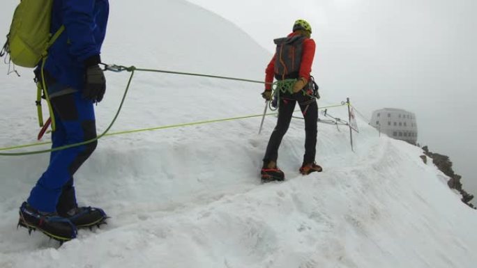 男人正在爬到山顶战胜自然挑战缆绳