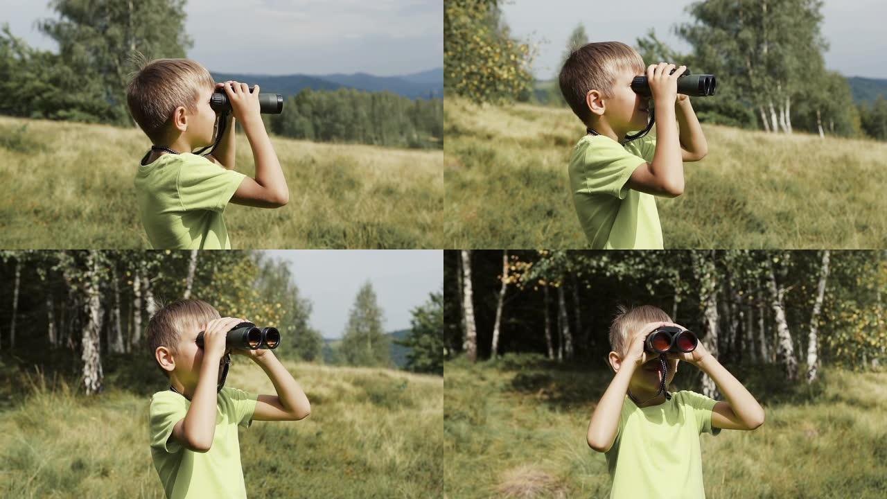 男孩站在山顶上，看着双筒望远镜