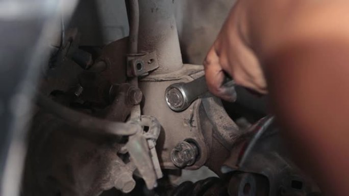 汽车机械师用风挡拧紧休克吸收器螺栓和螺母