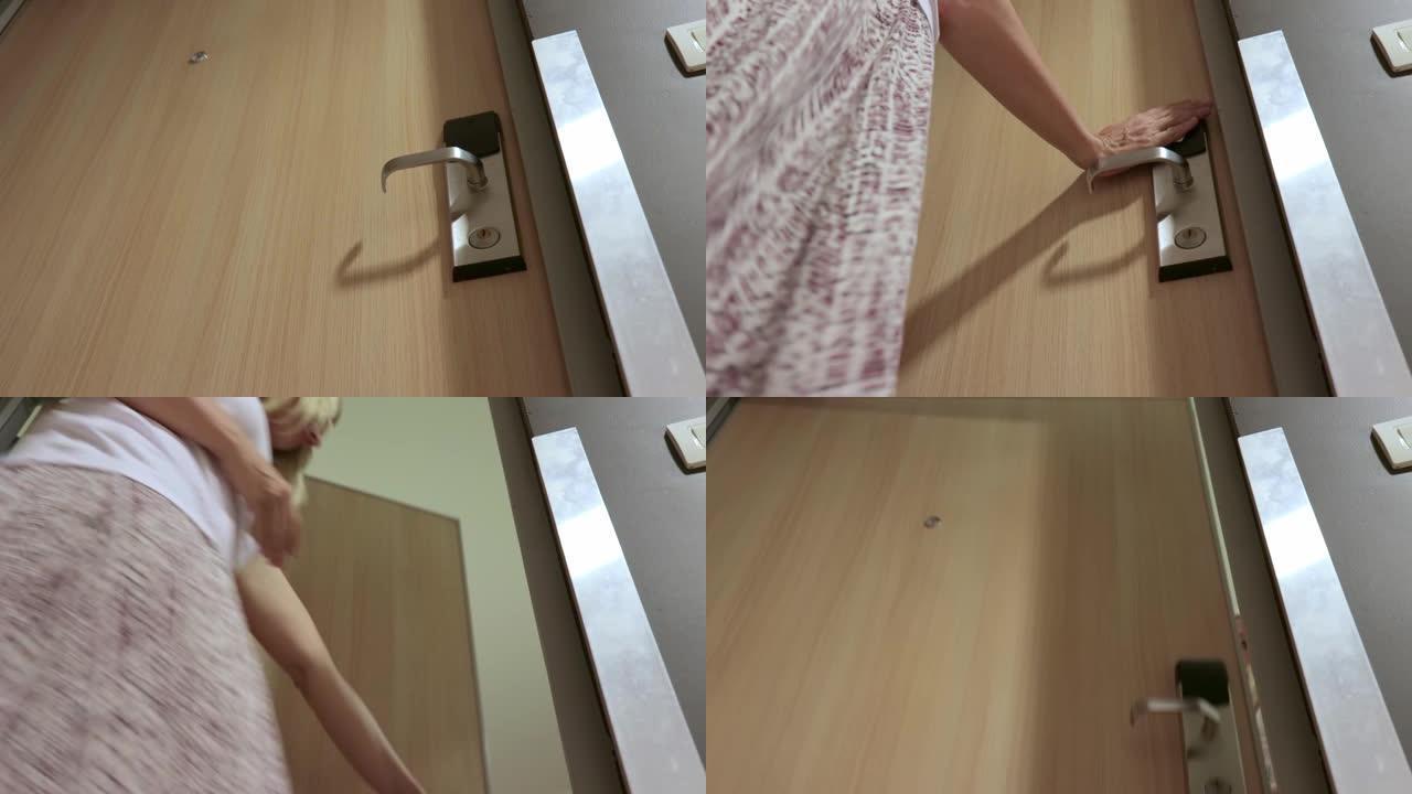 女人通过将门禁卡连接到电子安全锁上，打开门并进入房间来解锁酒店房间的门