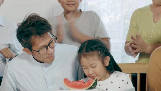 泰国女孩和她的父亲在吃西瓜的游戏中